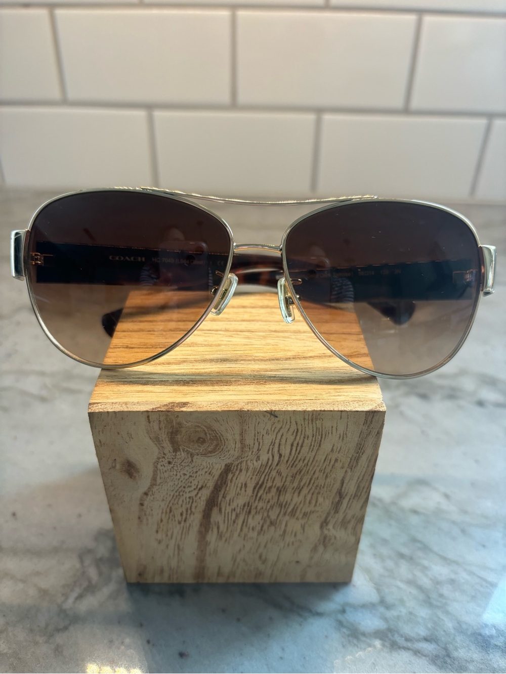 Coach Silver Aviator Sunglasses with Brown Gradient Lenses.